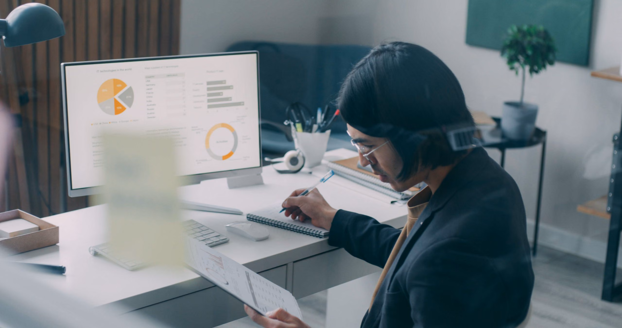 Analyst reviewing a reporting dashboard with charts on a desktop monitor
