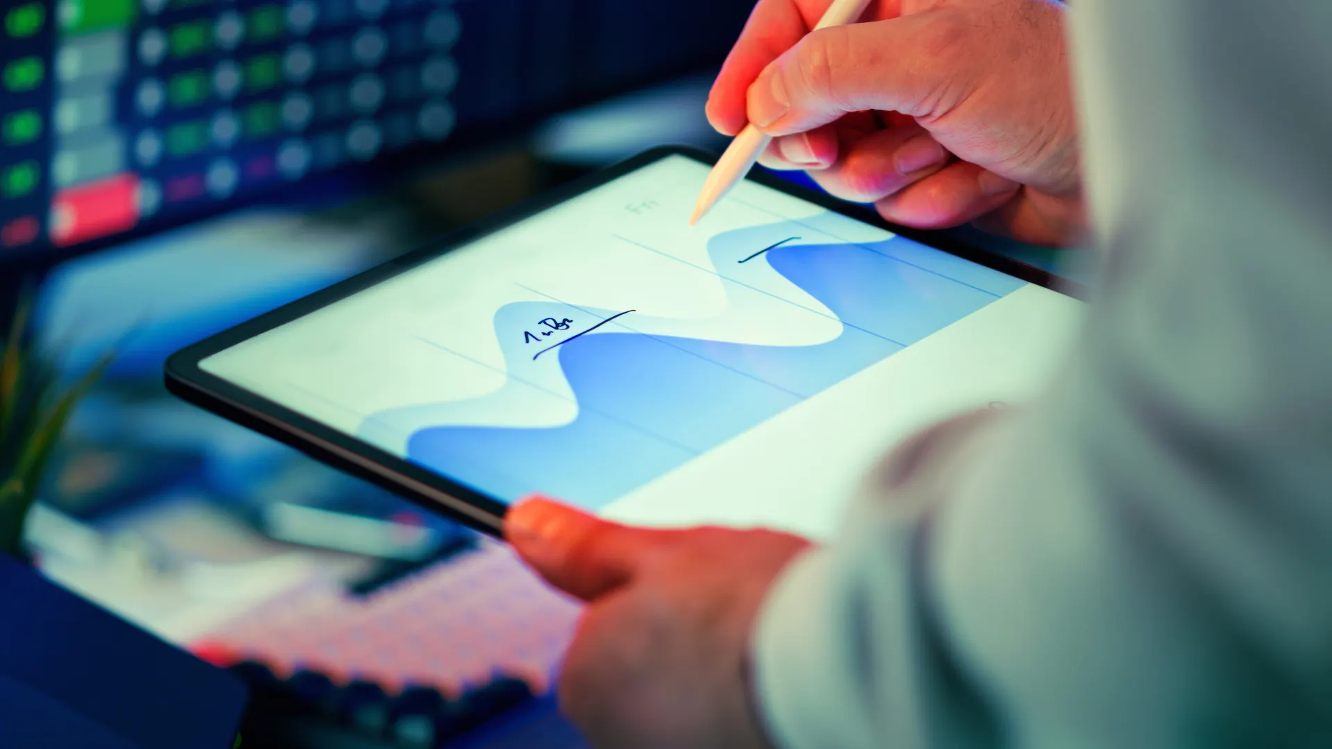 Professional analyzing data chart on a tablet with stylus in an office setting