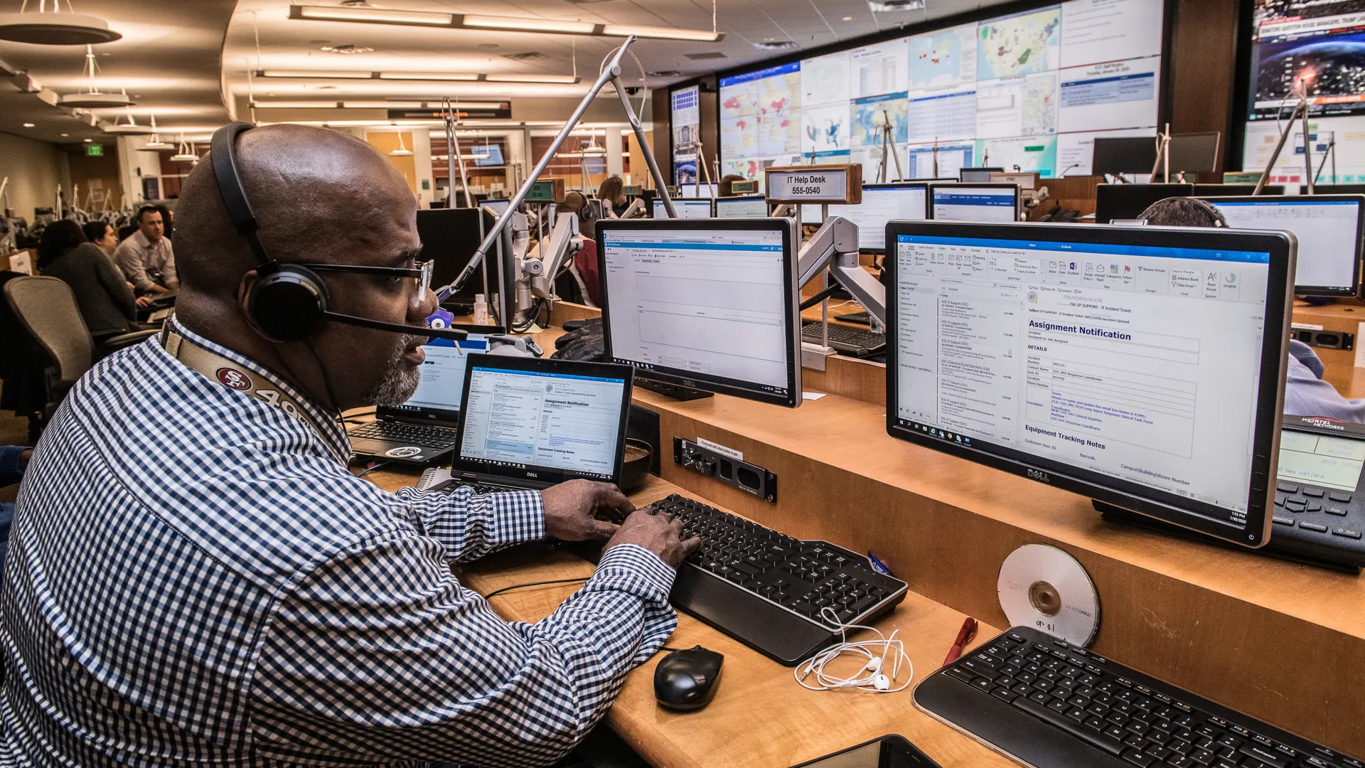 Focused man in office working on computers, engaged in technical research and communication