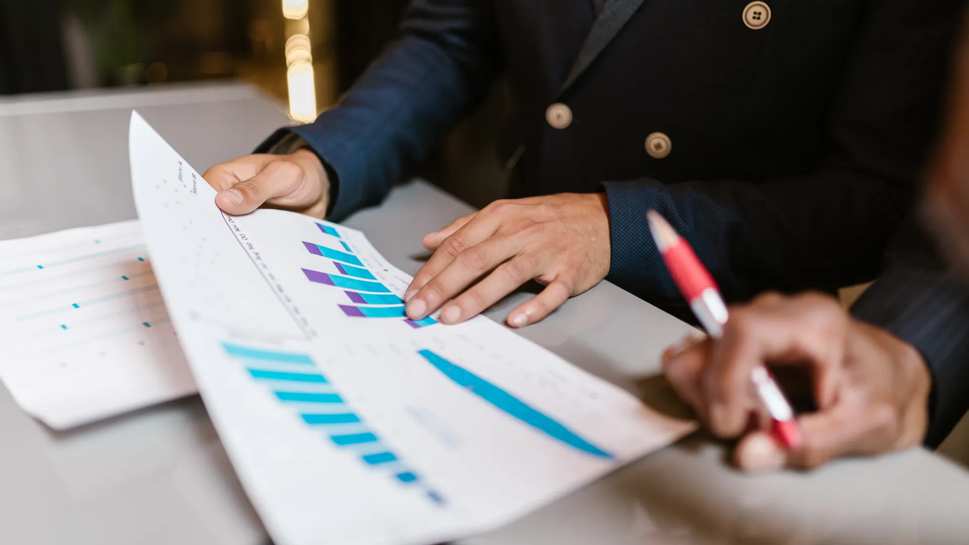 Close-up of professionals reviewing financial graphs at a business meeting