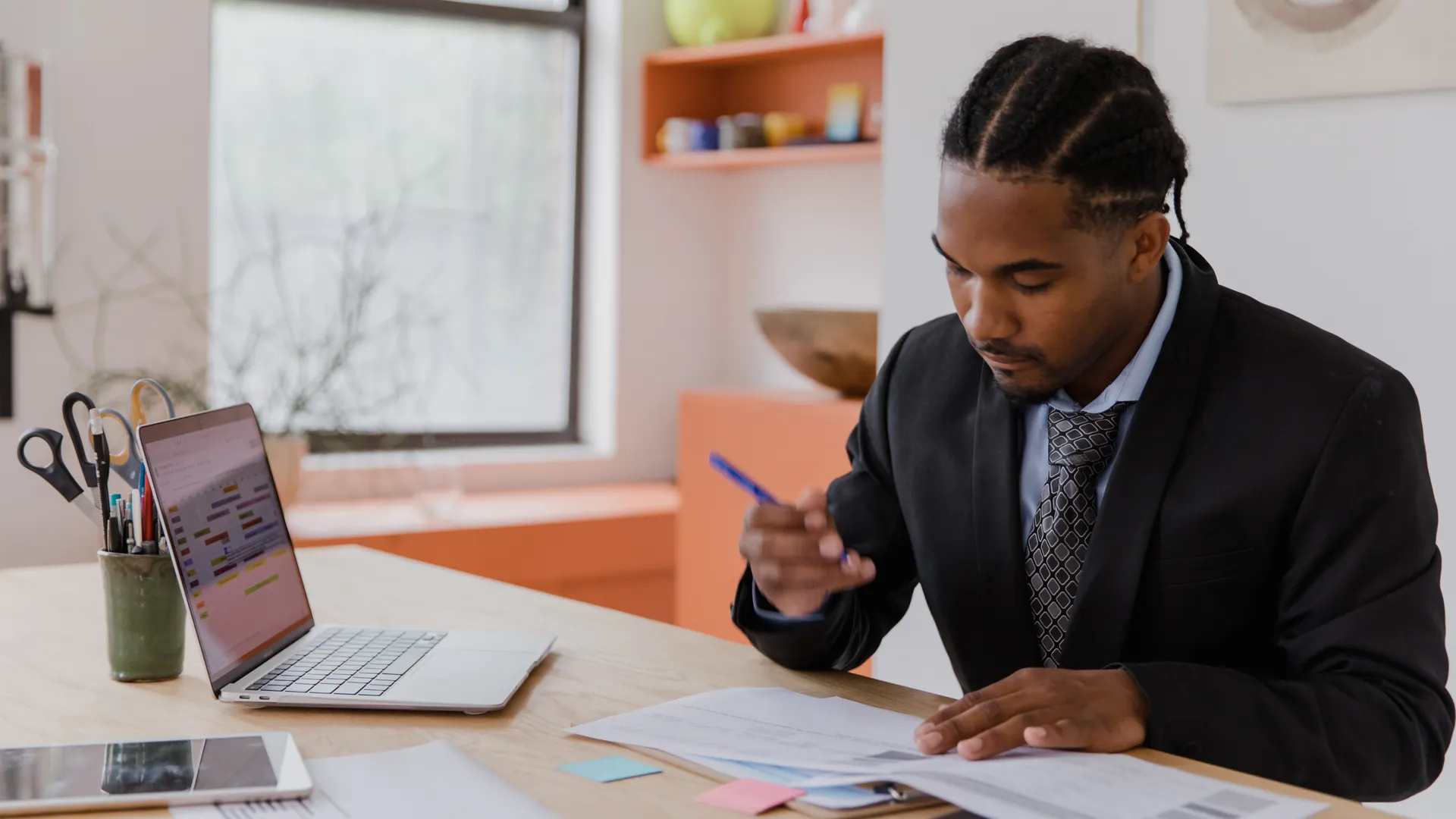 A professional businessman working at his desk, reviewing documents in a modern office environment