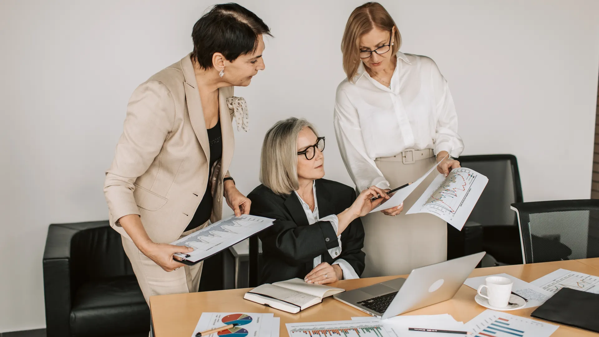 Group of senior businesswomen discussing financial charts during a formal meeting