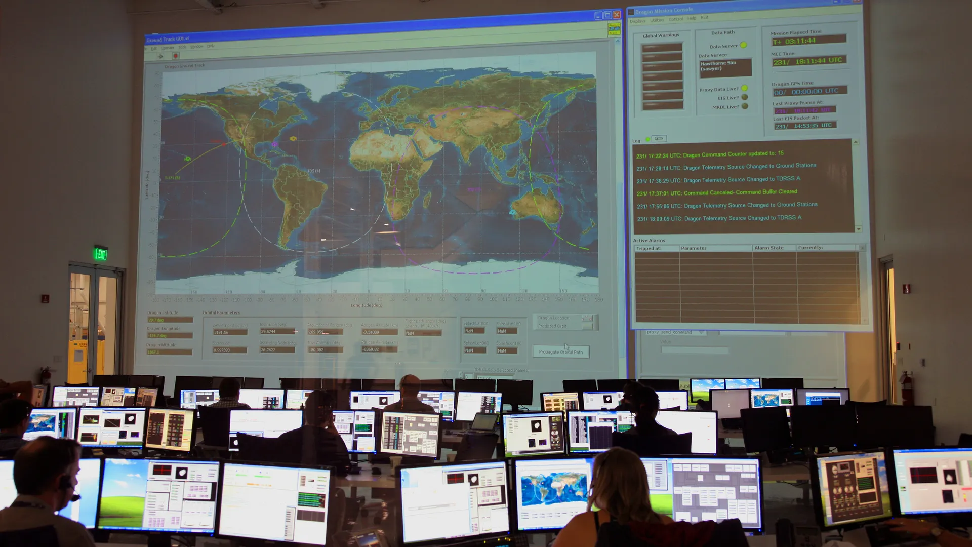 Back view of unrecognizable employees working on computers in flight control room