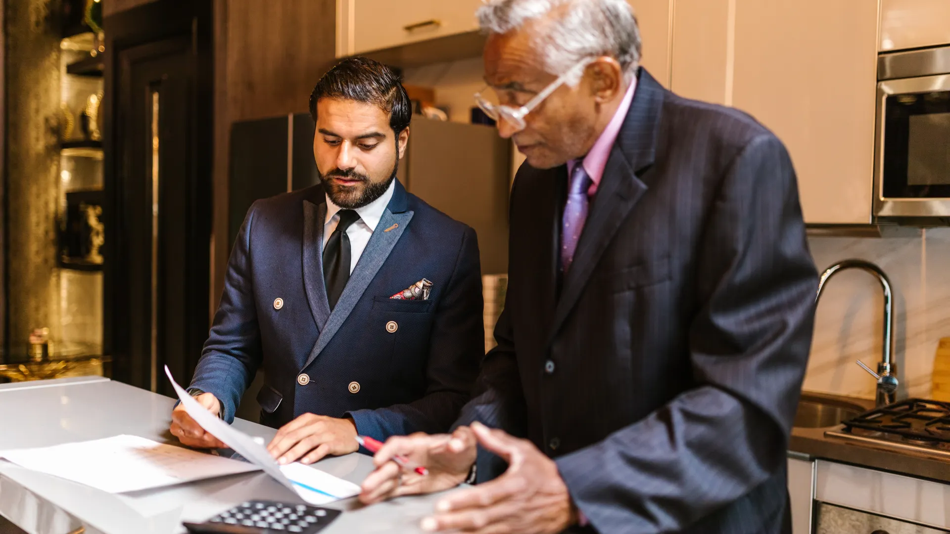 Two businessmen reviewing documents, engaged in a focused discussion indoors