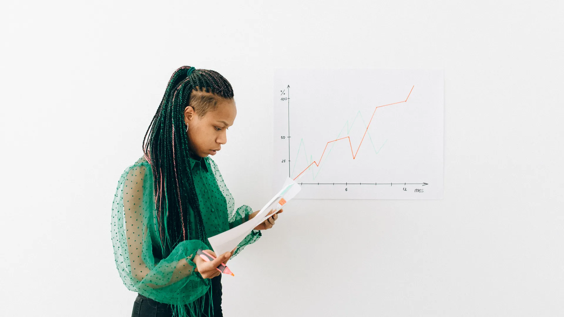 African American woman inspecting documents and graph charts indoors