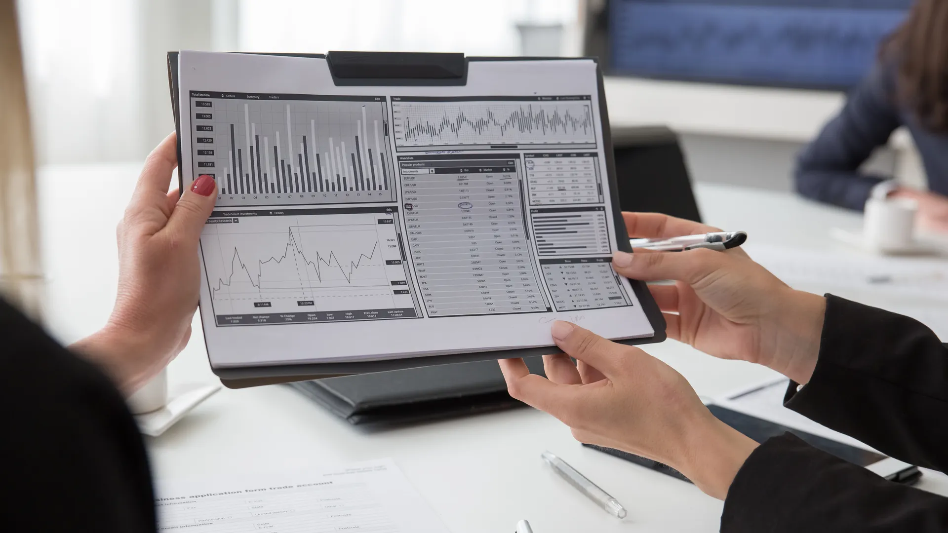 Professionals reviewing data charts on paper during a business meeting