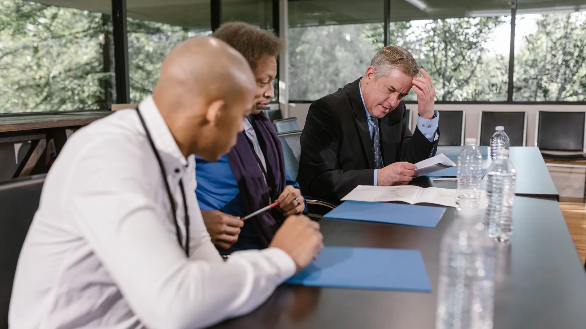 Group of diverse colleagues in a business meeting reviewing documents indoors