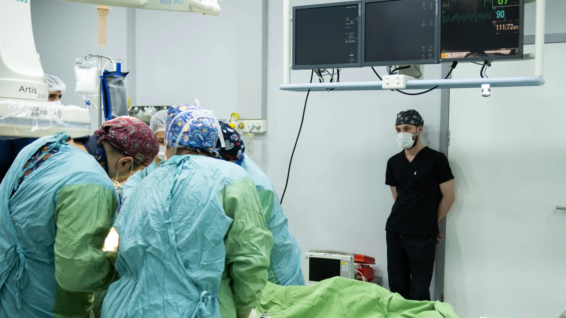 A medical team in full surgical attire performing an operation