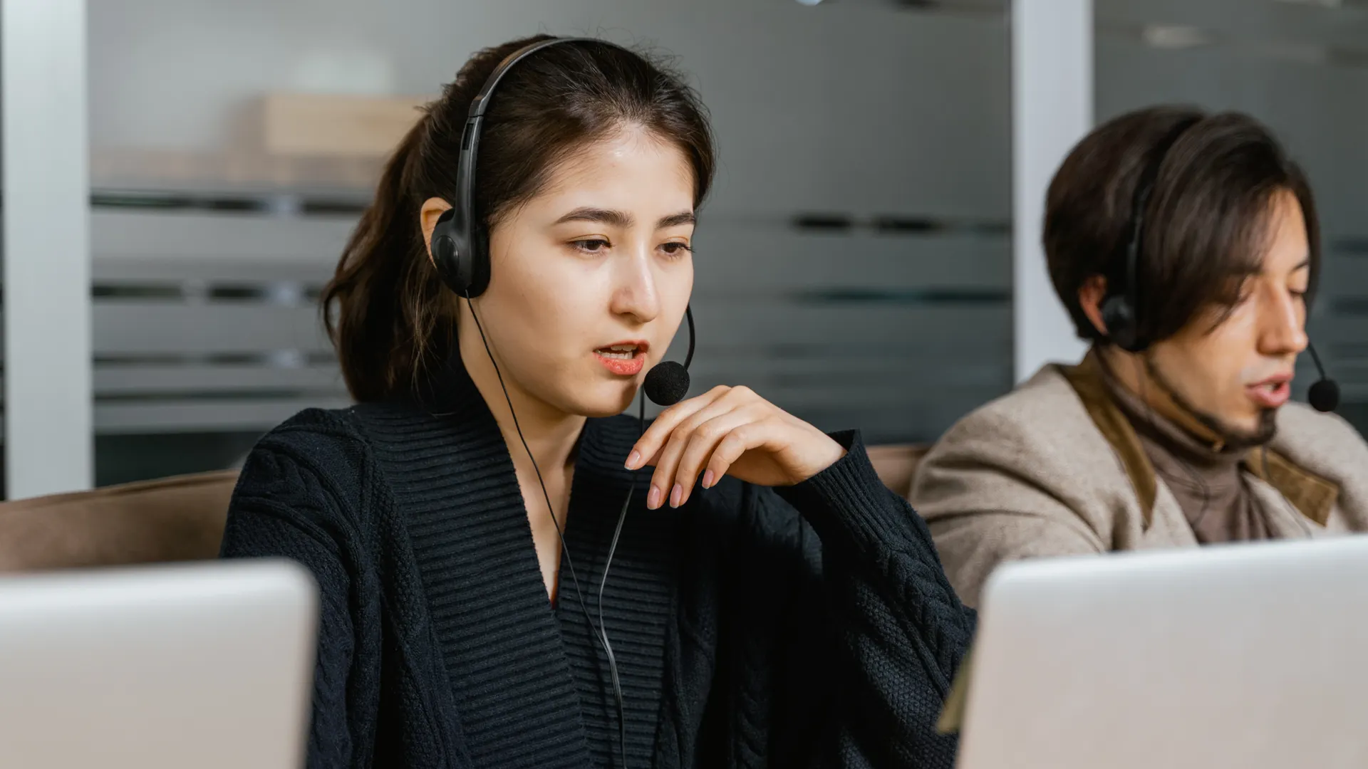 Two call center agents providing customer support in a modern office setting