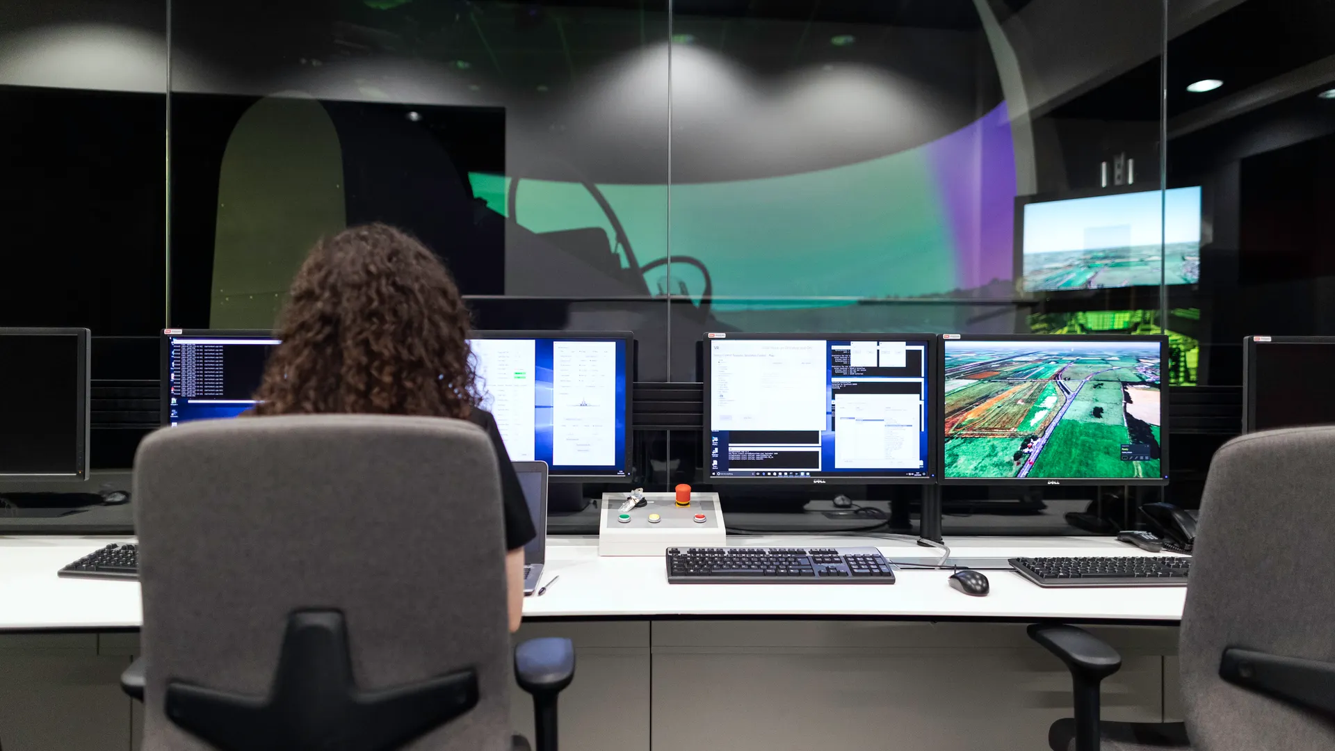 Female engineer managing multiple screens during a technology simulation in a control room