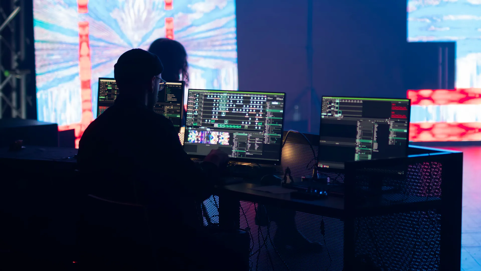 A stage technician monitors multimedia displays during a live event setup
