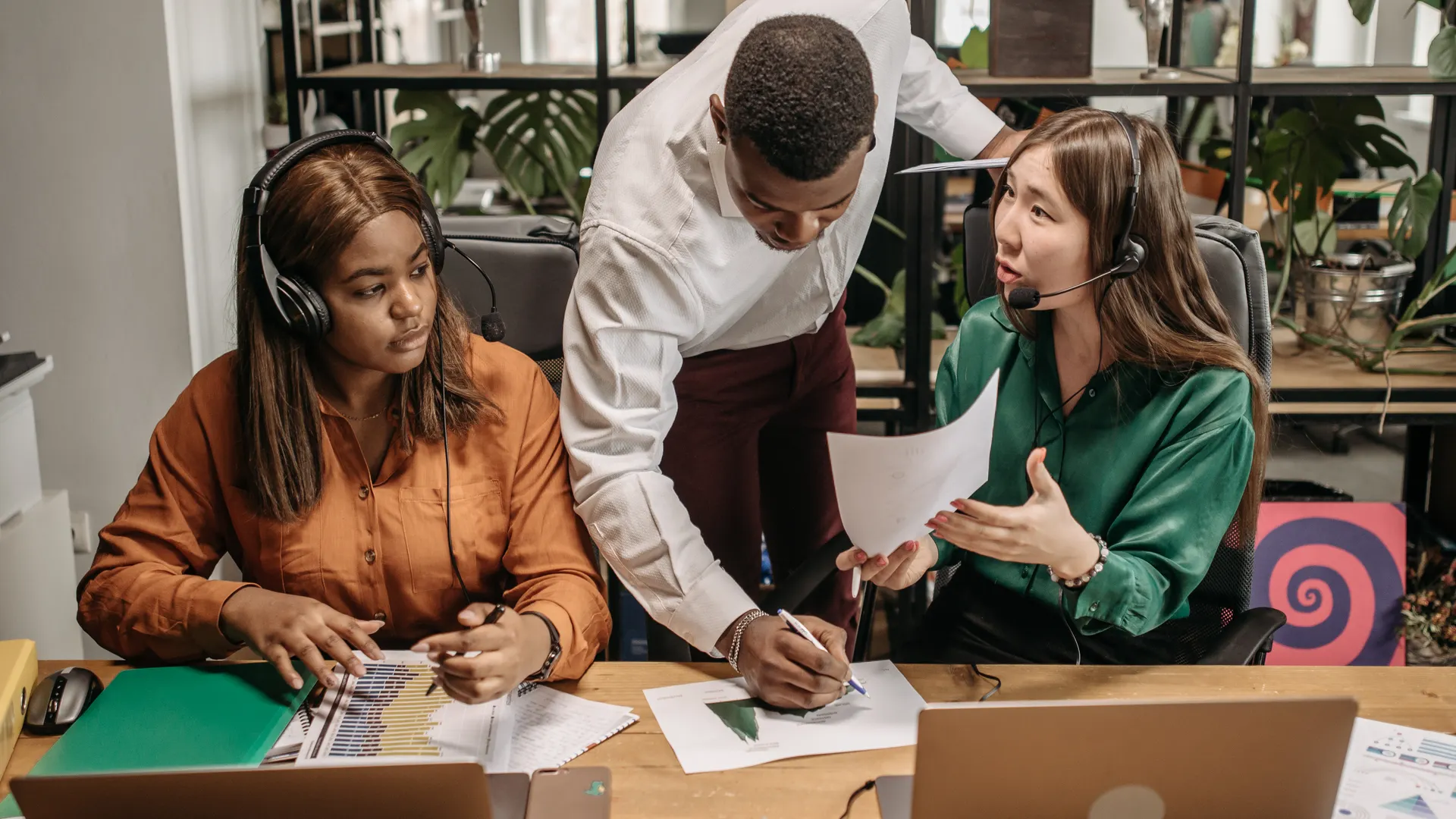 Diverse team collaborating in an office setting with technology and reports