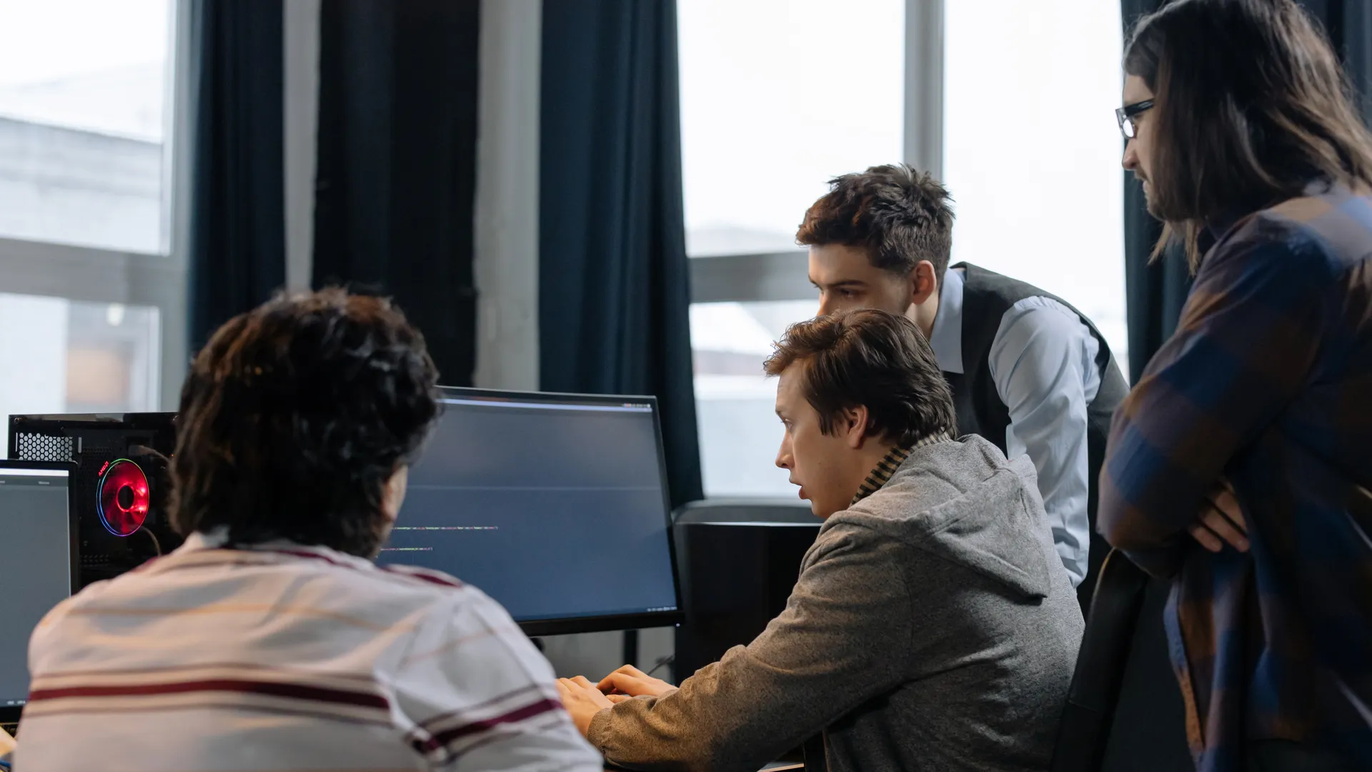 Group of developers working together on a computer programming project indoors