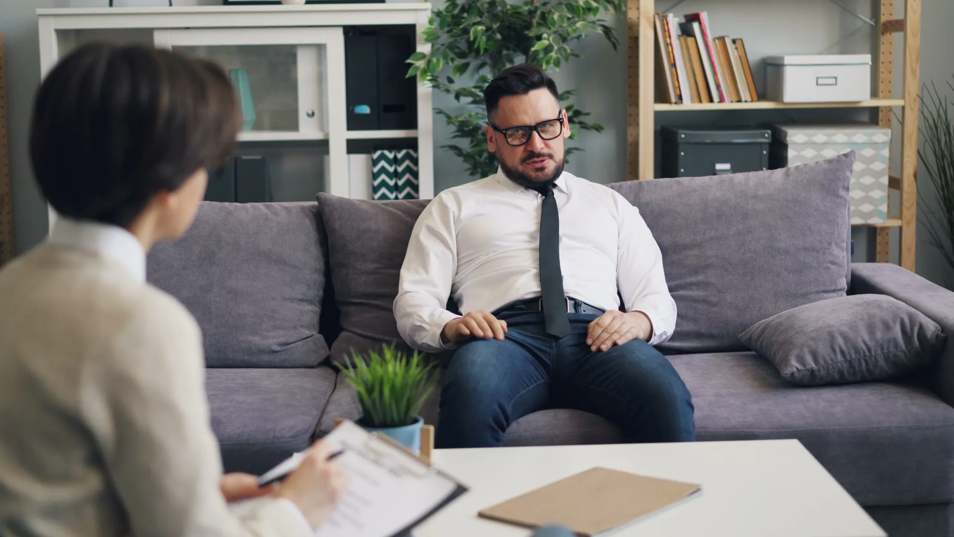 Man having a therapy session with a psychologist in a cozy office environment