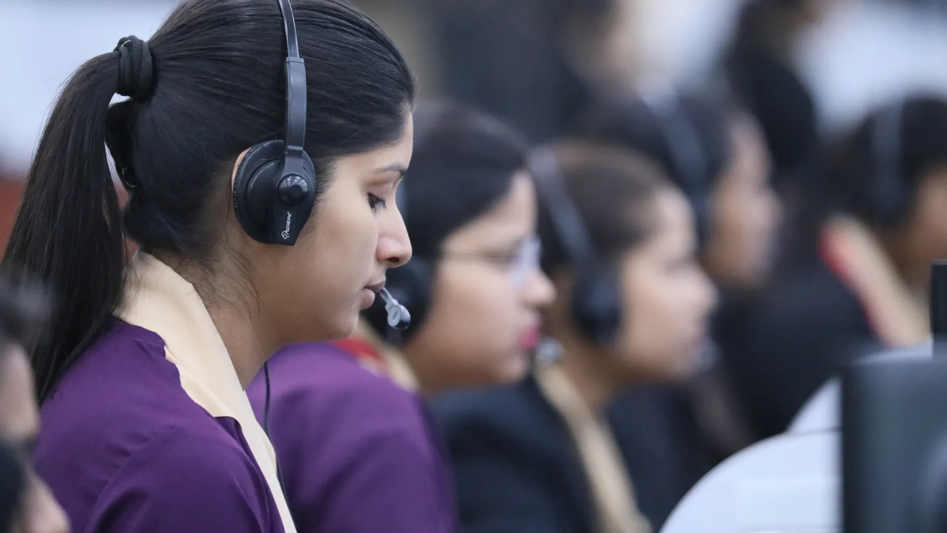 Call center agents wearing headsets working in a focused office environment