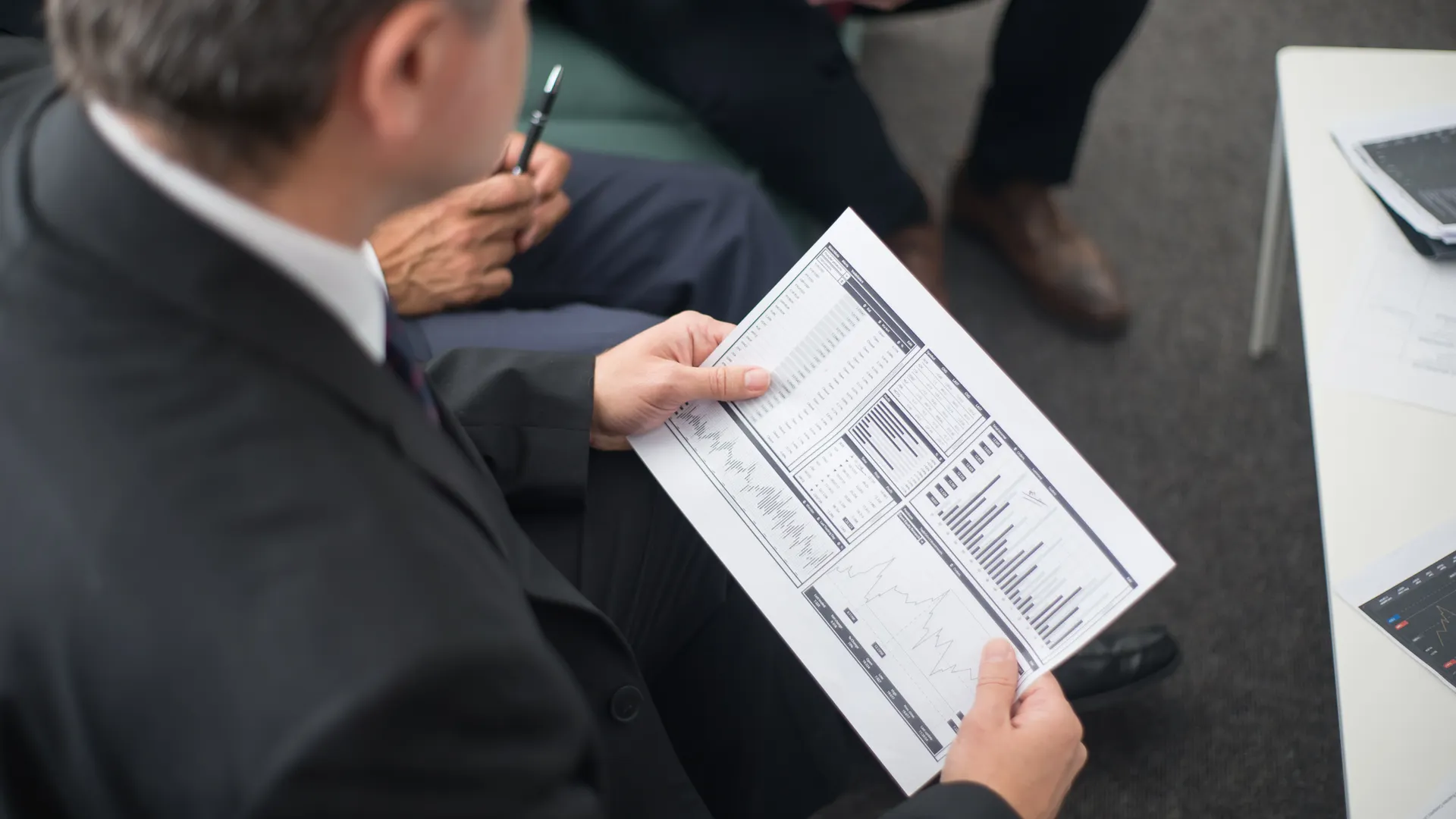 Two businessmen analyze financial documents during a meeting