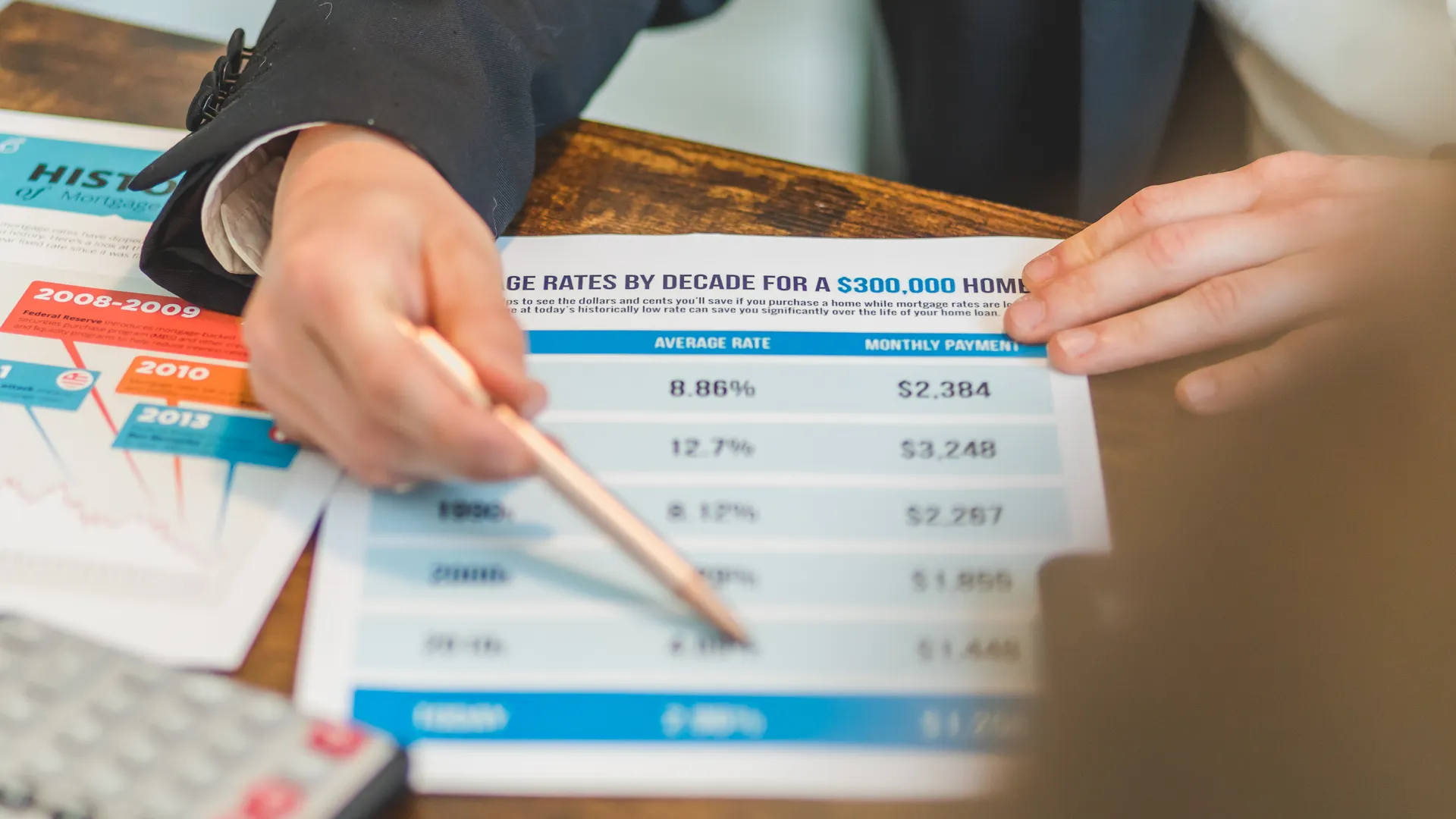 A close-up of hands analyzing mortgage rate documents