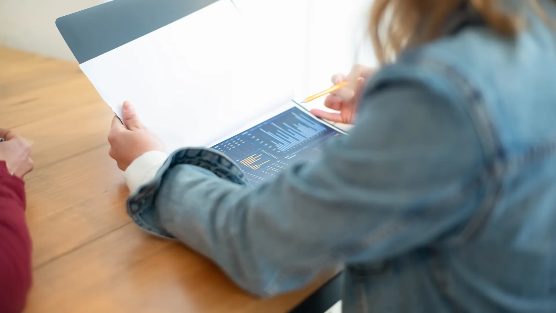 Business meeting discussion with focus on data charts and documents on a desk