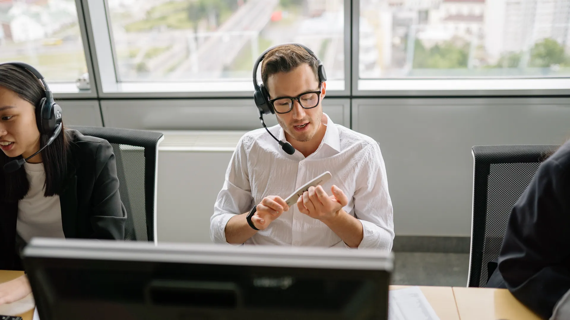 Call center agents wearing headsets and working at their desks in a modern office setting