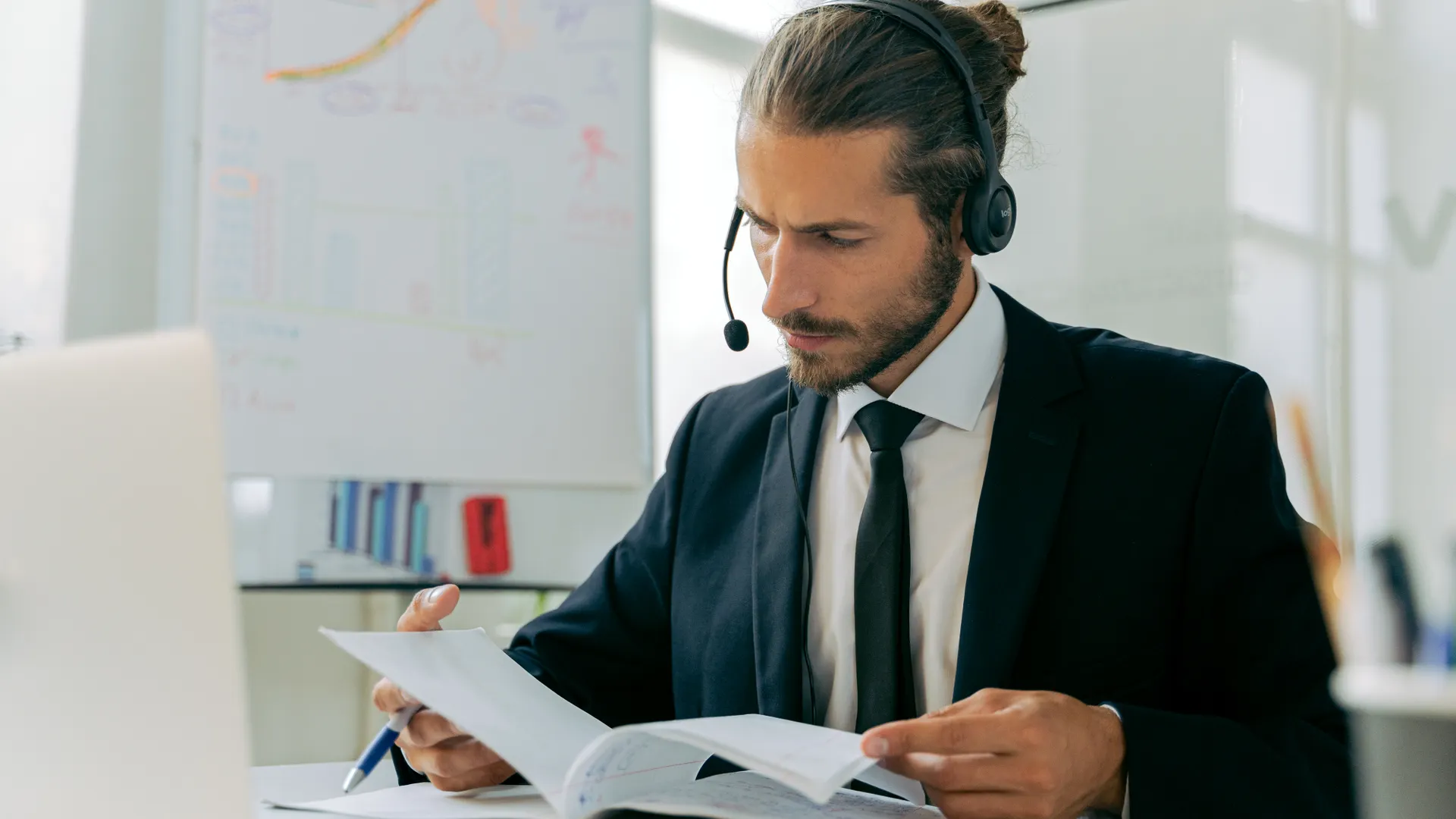 Focused business professional handling customer service tasks with a headset in an office setting