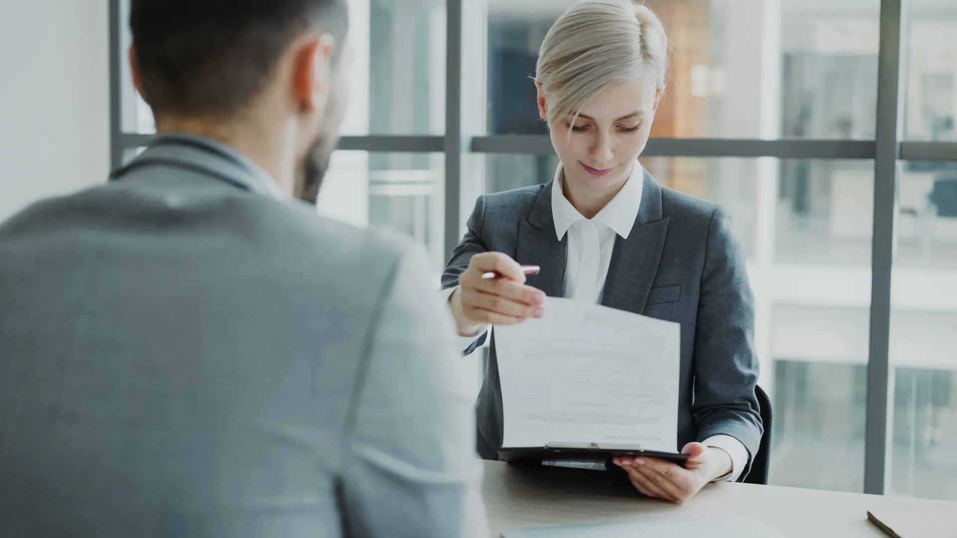 Business professionals reviewing a contract in a modern office setting