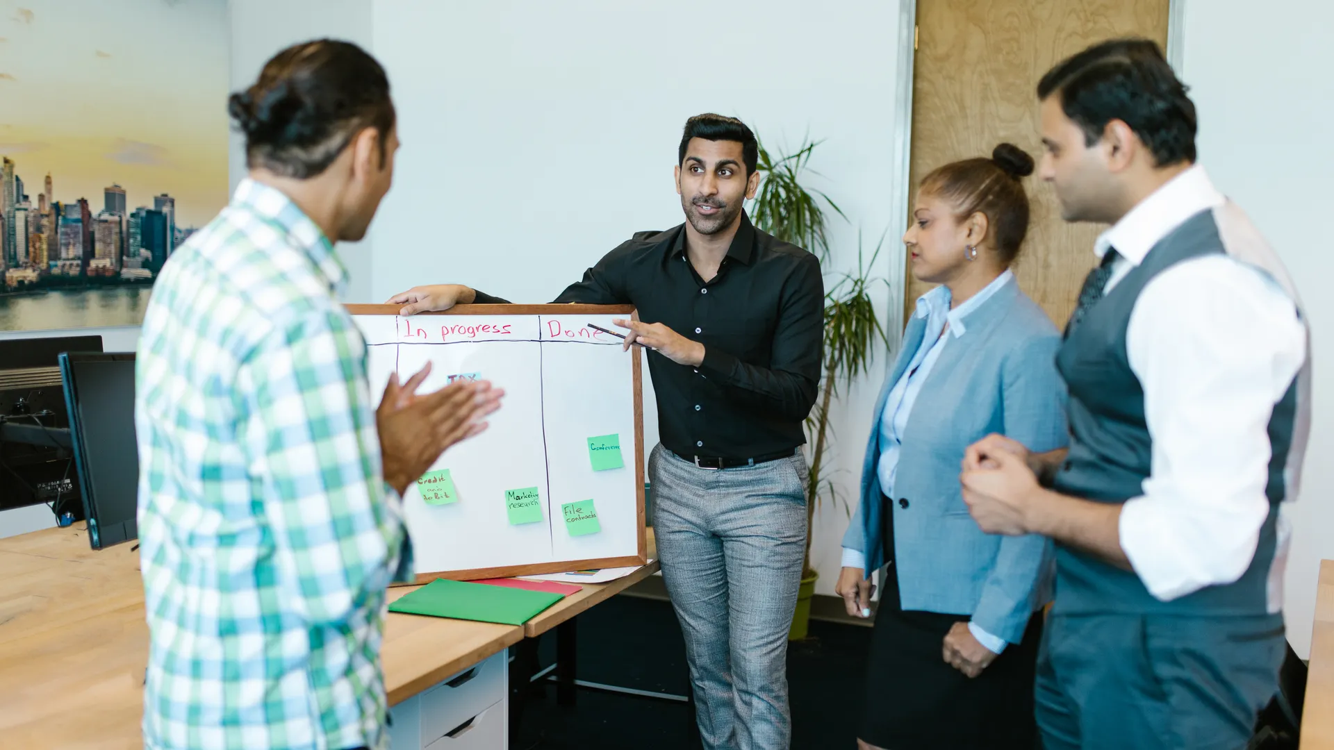 Diverse team discussing project progress with a board in a modern office