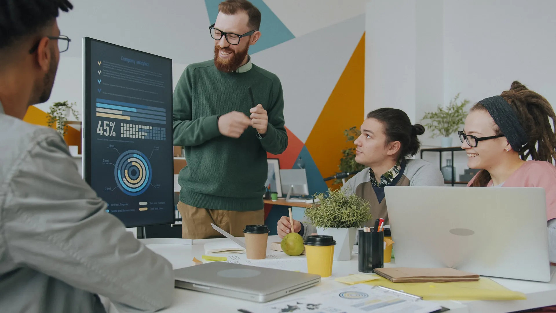 A diverse team engaged in a business meeting, analyzing company metrics on a presentation board