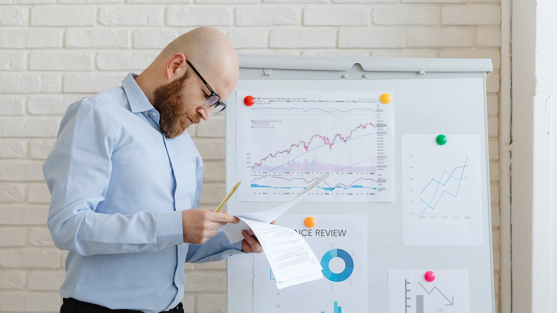 Business person in an office reviewing financial documents on a whiteboard