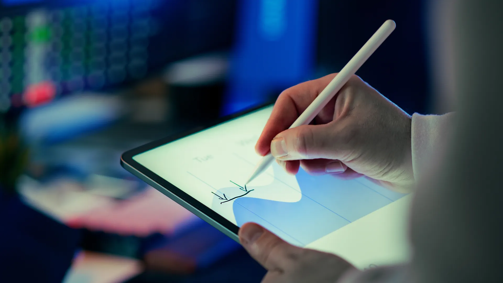Business person using a stylus to analyze data on a digital tablet in an office setting