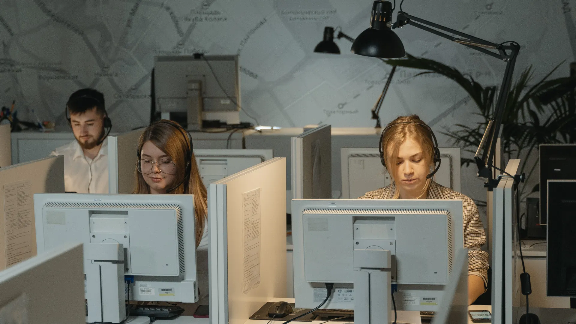 Call center agents working diligently with computers and headphones, providing customer support
