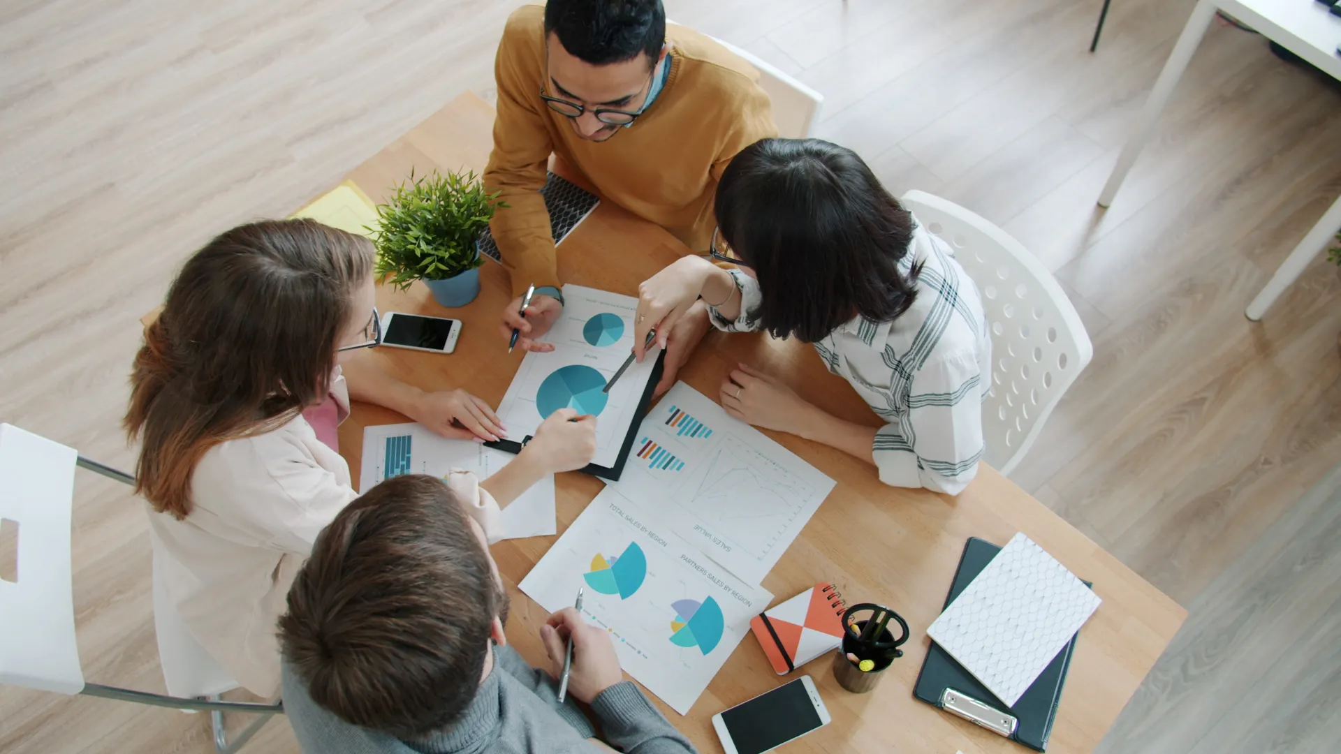 Group of professionals reviewing business charts around a table
