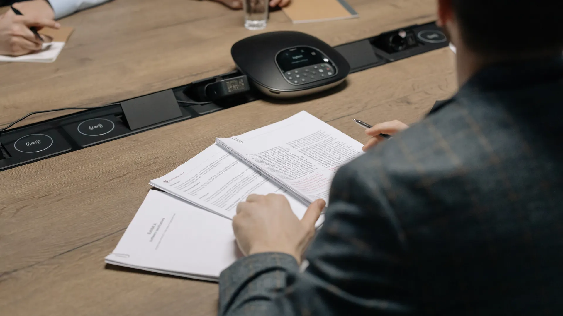 Close-up of business professionals reviewing documents during a meeting in a modern office setting