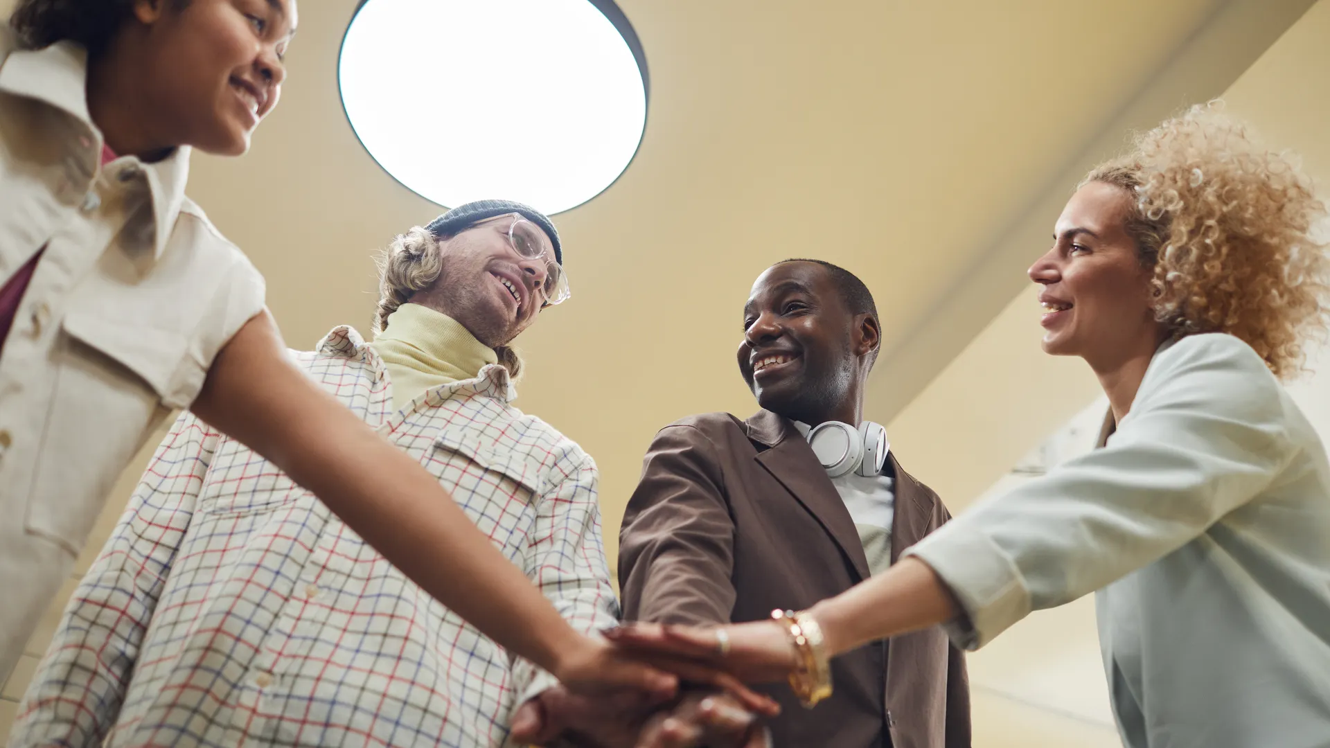 A diverse group of colleagues joyfully engaging in teamwork during an indoor office meeting