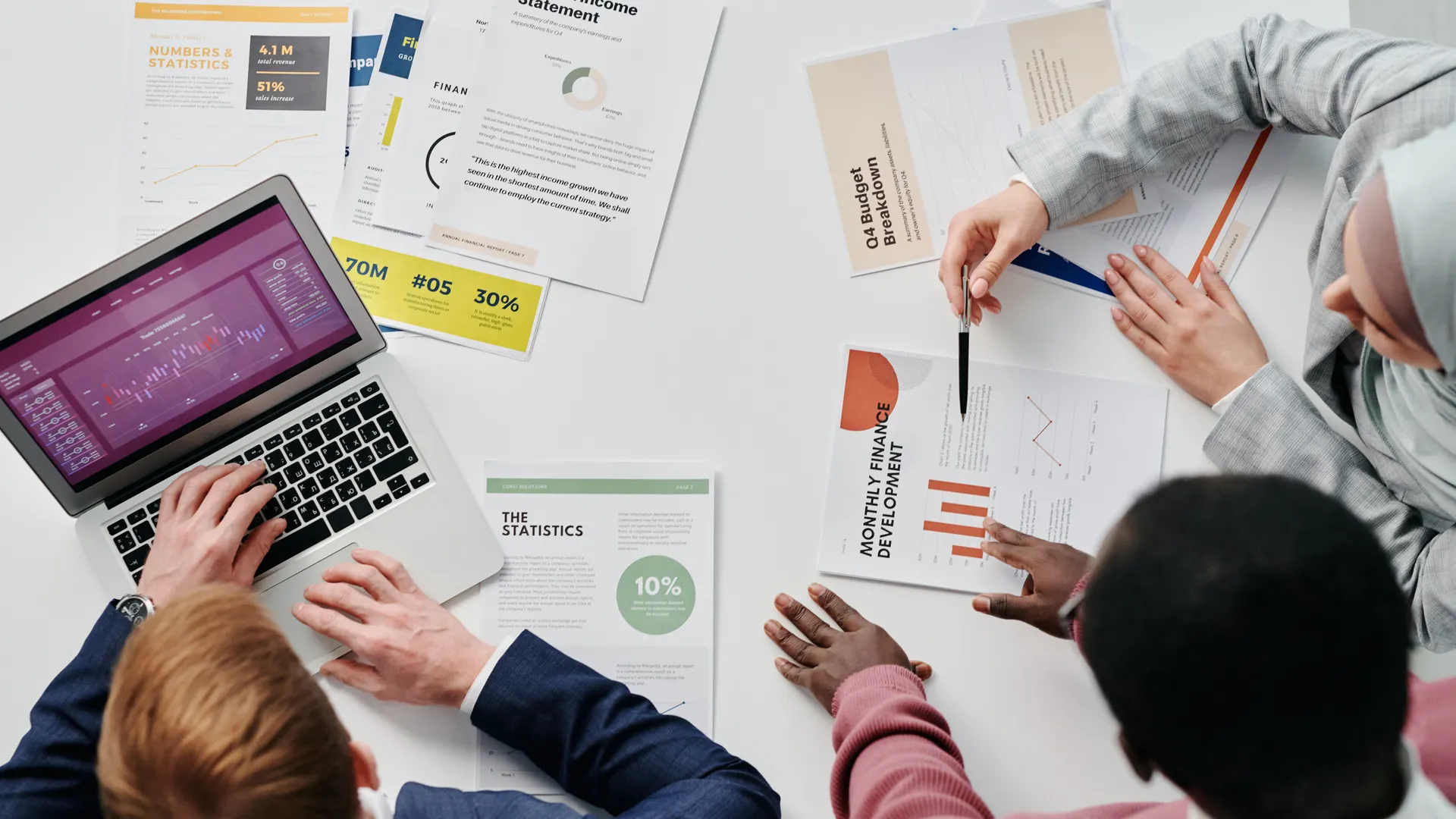 Business meeting with professionals discussing financial reports and graphs at a work desk