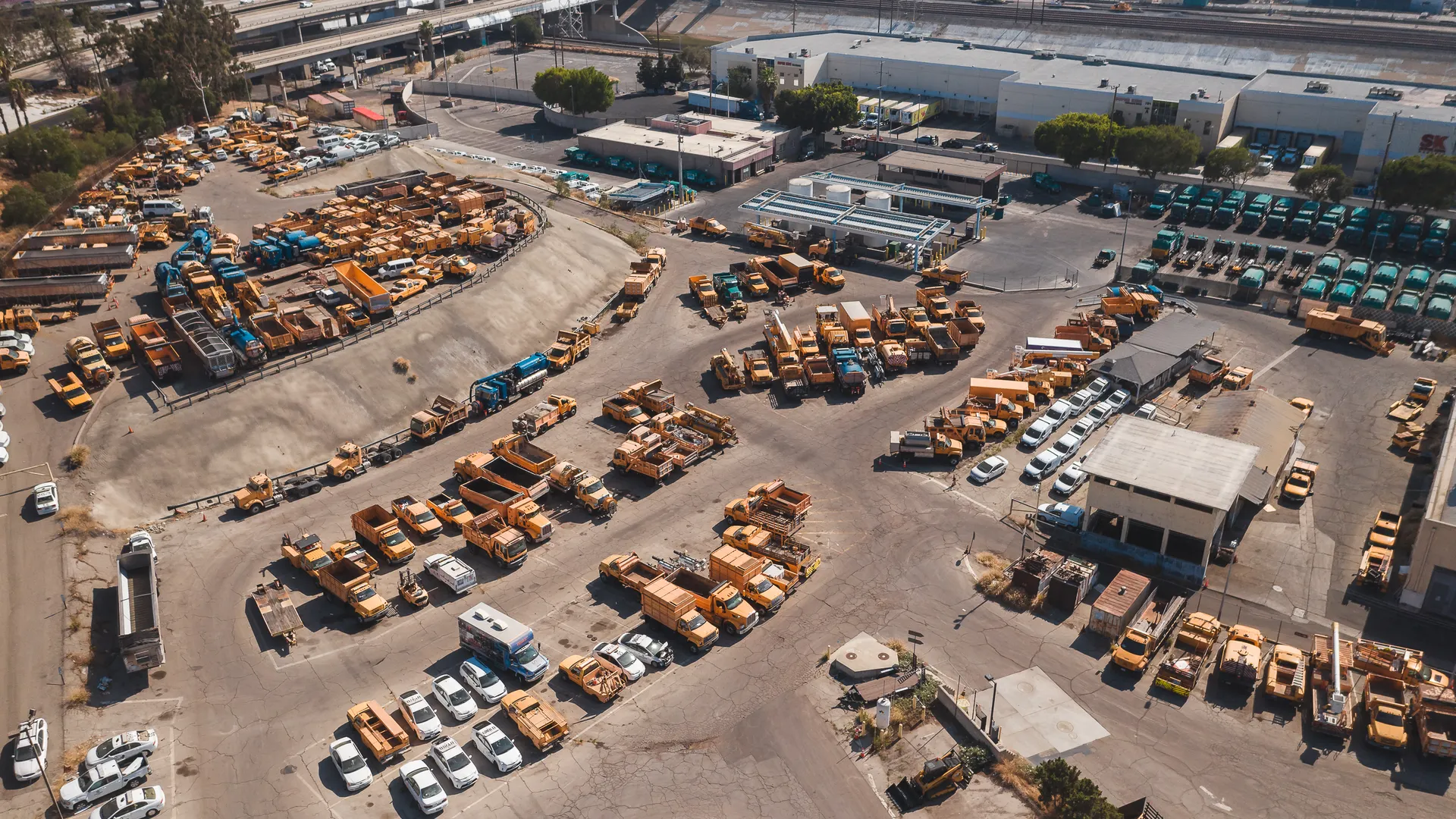 Aerial shot of an industrial truck parking lot in an urban area during daylight