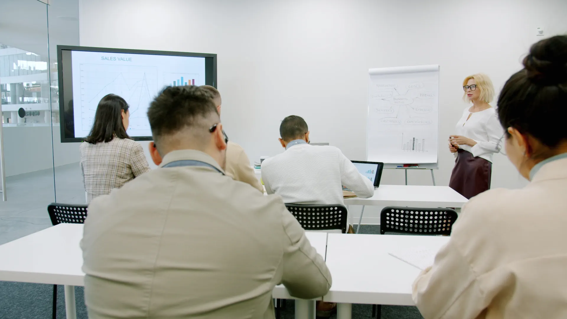 A business professional presenting in a modern, well-lit office environment
