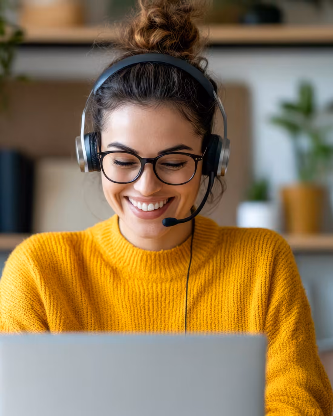 An e-commerce support agent on a headset answering a shopper’s query on her laptop