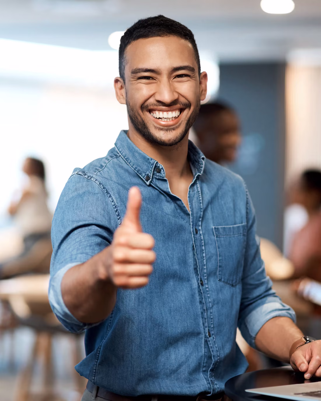 A contact centre agent at his desk giving a thumbs up after a coaching session